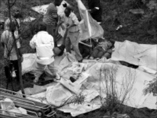 TRAGEDY: Rescue workers remove the dead while others are still lined up before being covered up after two trucks collided head-on in Bushbuckridge. 11/11/08. Photo: Riot Hlatshwayo. © Sowetan.