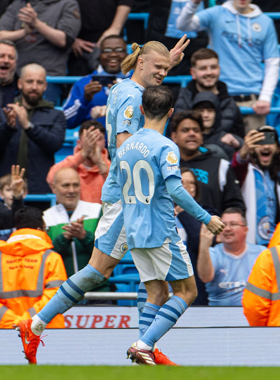 Manchester City's Erling Haaland (L) celebrates with Bernardo Silva after scoring his third goal against Wolves