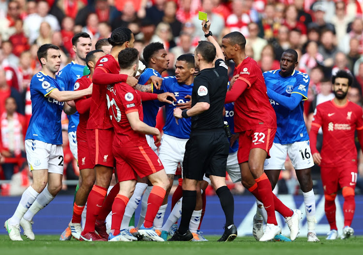 Sadio Mane of Liverpool (hidden) is shown a yellow card by referee Stuart Attwell during the Premier League match between Liverpool and Everton at Anfield on April 24, 2022 in Liverpool, England. Picture: GETTY IMAGES/CLIVE BRUNSKILL