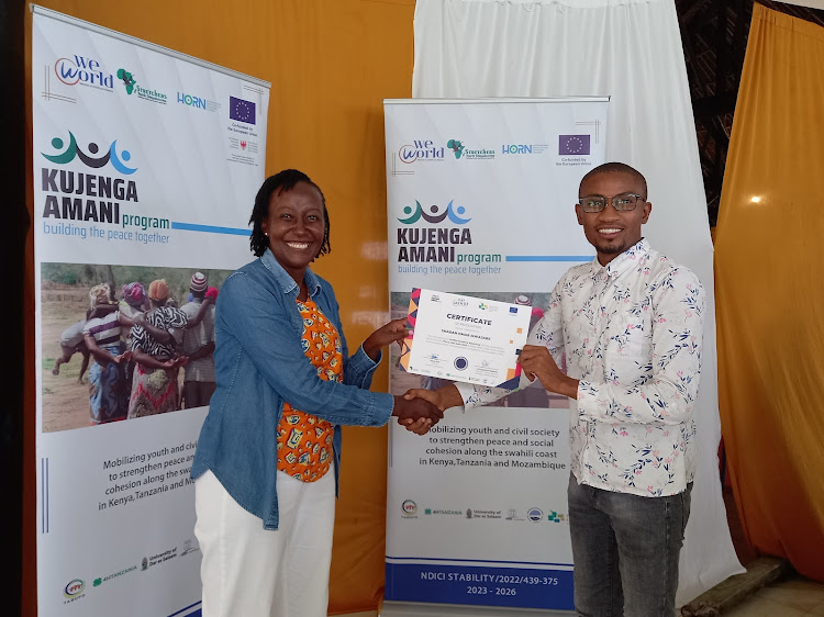 Writer Shaban Omar receives a certificate from a WeWorld consultant Mary Kiio following completion of three-day training on conflict sensitive reporting at the Safari Beach Hotel in Kwale County on Friday, April 19, 2024.