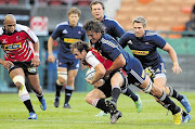 NOT VERY FRIENDLY: Eben Etzebeth of the Stormers tackles Michael Bondesio, centre, of the Lions, during the 2012 pre-season friendly match at Newlands Stadium in Cape Town