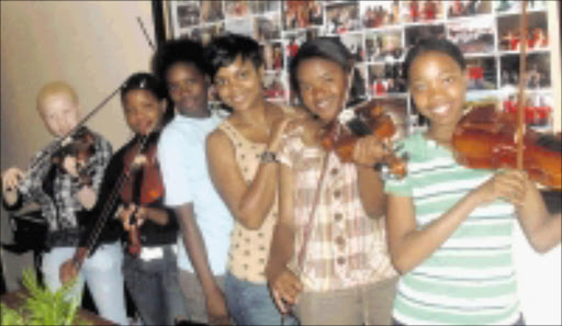 GETTING INVOLVED: AS singer Puff Johnson, fourth from left, with Limpopo Youth Orchestra members. 15/11/2009. © Sowetan.