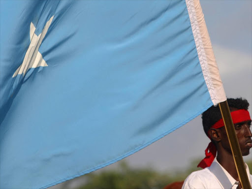 A protester carries the Somali national flag during a demonstration against al Shabaab militant group after last weekend's explosion in KM4 street in the Hodan district at the stadium Koonis in Mogadishu, Somalia October 18, 2017. /REUTERS