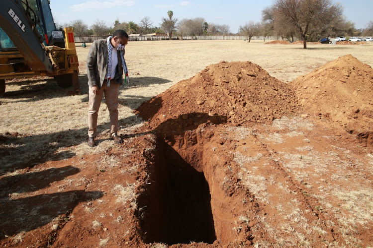 Dr Bandile Masuku inspects a grave at Honingnestkrans cemetery in Tshwane.
