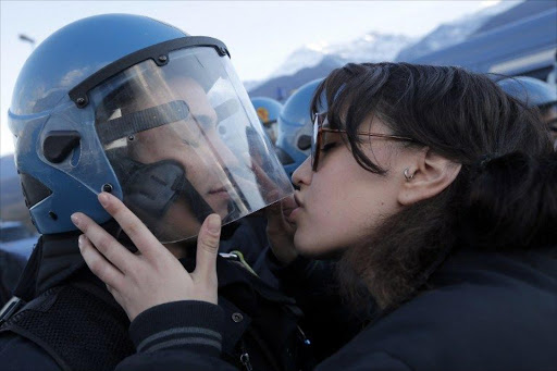 A demonstrator kisses a riot police officer during a protest in Susa against the high-speed train (TAV in Italian) line between Lyon and Turin.