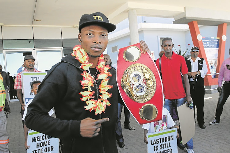 A garlanded IBF champion Zolani ‘Last Born’ Tete shows off his belt after touching down at the East London Airport yesterday following his victory over Englishman Paul Butler on Friday.
