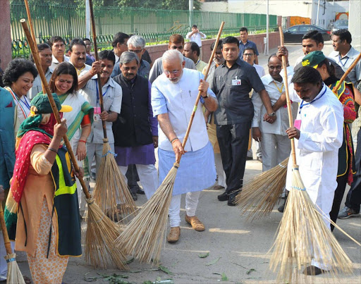 Indian Prime Minister Narendra Modi (C) with other workers cleaning a road, in New Delhi, India. Picture Credit: EPA