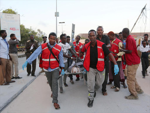 Rescue personnel carry the body of a man killed at the scene of a blast near the Mogadishu sea port in Mogadishu, Somalia, May 24, 2017. /REUTERS