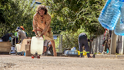 A man makes use of a skateboard to carry a 25-litre container filled with fresh spring water from the Springs Way water point in Newlands, Cape Town. 