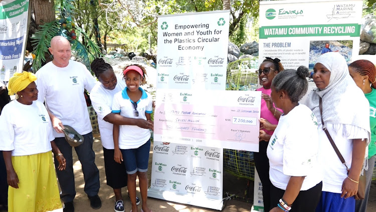 Watamu Marine Association project manager Steve Trot with members receive a cheque for Sh7.2 million from the Coca-Cola Foundation's Pauline Mwaura on September 17, 2022.