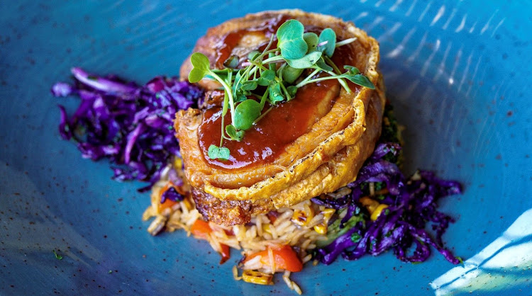 Slow-roasted pork belly topped with citrus-soy glaze, on a bed of coriander-infused red cabbage