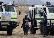 South African police carry weapons taken from stricking miners in Marikana on September 15, 2012 at Lonmin's platinum mine after hundreds of workers regrouped in a shantytown near where police shot dead 34 people last month.