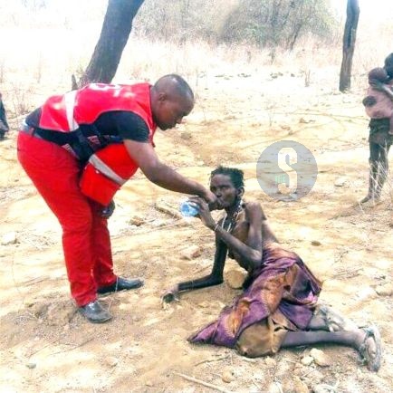 An old mother being assisted by Red cross officer in Laisamis.
