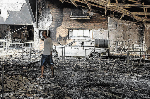 CARBON-DATED: A man inspects the charred interior of the science faculty building after students set fire to it at the Mafikeng campus of the University of North West this week.