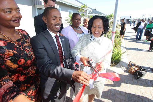 NEW BEGINNINGS: Ndlambe mayor Sipho Tandani helps Deputy Tourism Minister Tokozile Xasa cut the ribbon at the opening of the renovated Cannon Rocks worker cottages, watched by Vuyo Zitumane of the EC Parks and Tourism Agency and dignitaries