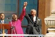 The late Anglican archbishop Desmond Tutu and Nelson Mandela salute the crowd from the balcony of the Cape Town City Hall.


