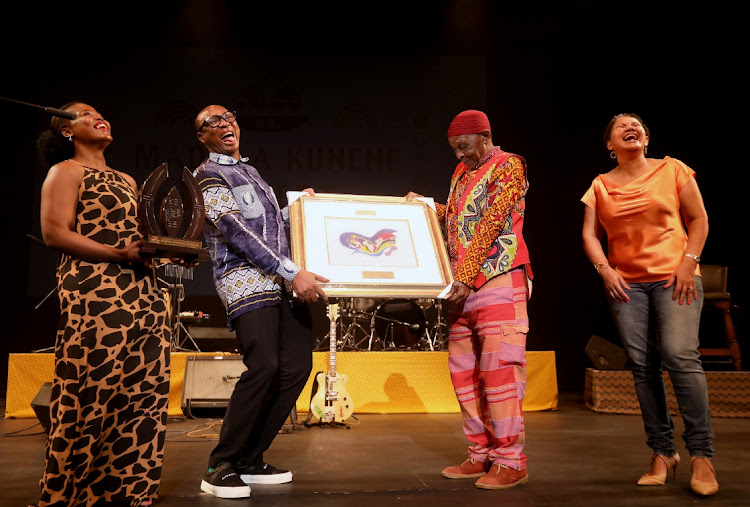 Minister of Sports, Arts and Culture Zizi Kodwa is flanked by Playhouse CEO, Linda Bukhosini and chairperson Khwezi Kunene as he honours Dr Madala Kunene with an award during his honorary concert at Playhouse in Durban.