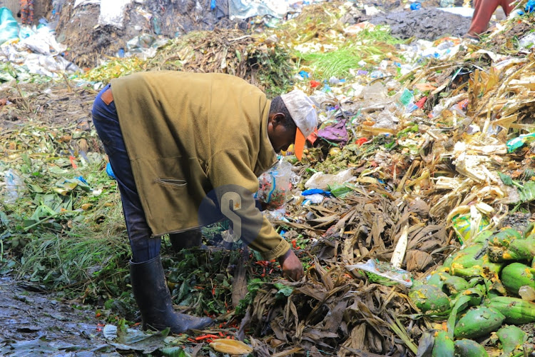 Man picks peppers from a hip at Muthurwa dumpsite which is located just too close to the market on April 16, 2024.