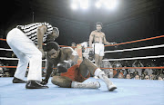 FLOORED: George Foreman tries to get off the canvas as referee Zack Clayton checks on him during his fight against Muhammad Ali, in Kinshasa, Zaire, in October 1974