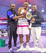 SA super middleweight hchampion Asemahle Wellem celebrates his win with trainer Phumzile Matyhila and manager Siya Zingelwa.