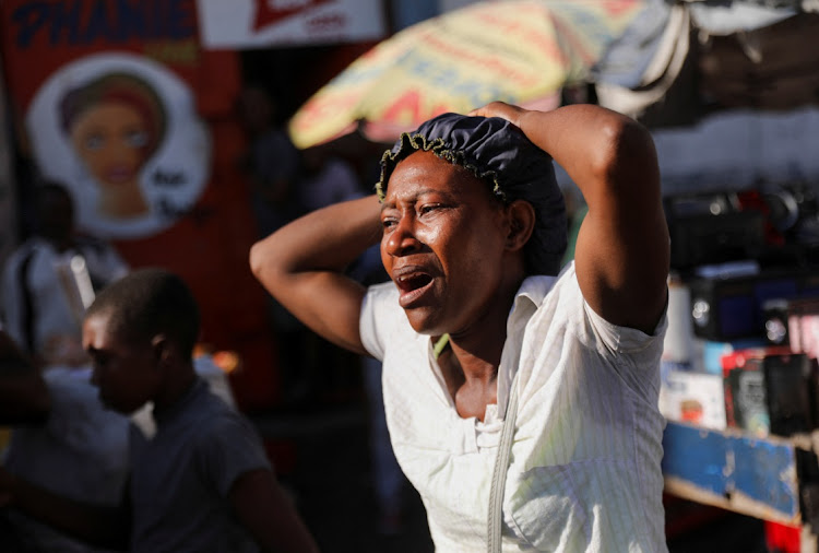 A woman reacts at a crime scene where the bodies of several people, who were shot dead earlier in the morning amid an escalation in gang violence, were being removed by an ambulance, in Port-au-Prince, Haiti, on March 18. Picture: REUTERS/RALPH TEDY EROL