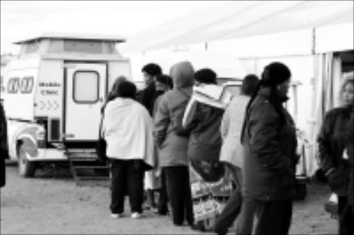 WHAT A PAIN: ANCWL delegates queue at a mobile clinic for treatment after apparently eating tainted food. Pic. Lucky Nxumalo. 07/07/08. © Sowetan.