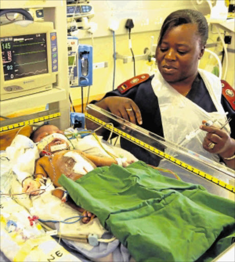 NURSING CARE: Sister Luyanda Gidi monitors the baby boy who was born with his heart outside his body after surgery inside the neonatal ward at Dora Nginza Hospital in Port Elizabeth. Photo: Brian Witbooi