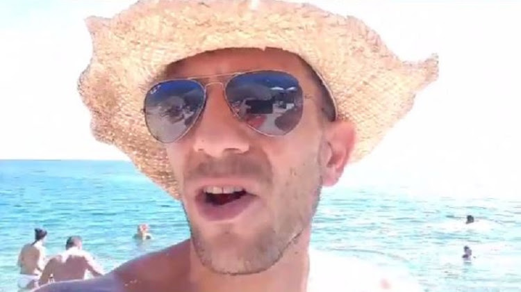 A screenshot of a video of Adam Catzavelos who used the 'K-word' at a beach.