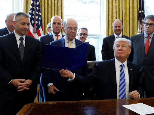 US President Donald Trump smiles after announcing a permit for TransCanada Corp's Keystone XL oil pipeline while TransCanada Chief Executive Officer Russell Girling (L), US Commerce Secretary Wilbur Ross (C) and US Energy Secretary Rick Perry (R) stand beside him in the Oval Office of the White House in Washington, US, March 24, 2017. /REUTERS