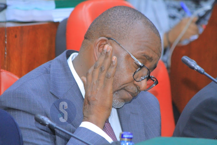 Agriculture Cabinet Secretary Mithika Linturi touches his jawline as he follows proceedings during the impeachment pre-trial hearing by the National Assembly select committee at County Hall on May 7, 2024.