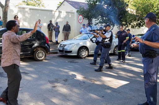 A photograph speaks a thousand words. Rhodes Vice Chancellor Sizwe Mabizela attempting to stop police from shooting rubber bullets at protesting students.