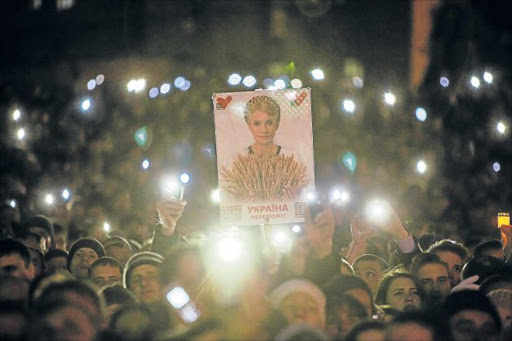 MARKING THE ORANGE: A crowd at Independence Square in Kiev, Ukraine, with posters of former Prime Minister Yulia Tymoshenko who led the 2004 Orange Revolution Picture: GETTY IMAGES