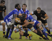 Jaguares' lock Tomas Lavanini (C) is tackled by Stormers' prop JC Janse van Rensburg (2nd-R), during their Super Rugby match at Jose Amalfitani stadium in Buenos Aires, Argentina on March 26, 2016.