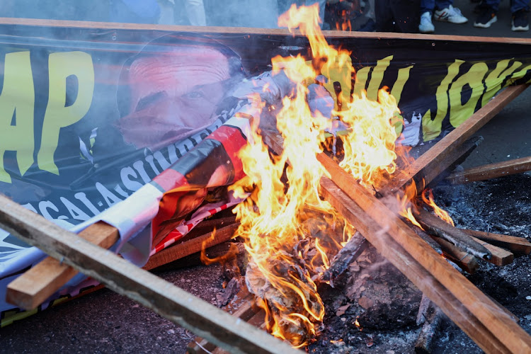 A banner depicting Indonesian President Joko Widodo is burnt during a protest after a verdict delivered by a court in Indonesia on two challenges to the outcome of February’s presidential election after losing candidates petitioned for a re-run and alleged the state had interfered in favour of the winner Prabowo Subianto in Jakarta, Indonesia, on April 22. Picture: REUTERS/AJENG DINAR ULFIANA