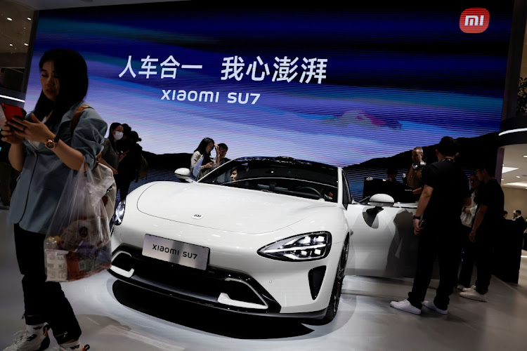 Visitors look at a Xiaomi SU7 electric vehicle displayed at the Beijing International Automotive Exhibition, or Auto China 2024, in Beijing, China, on April 25, 2024. Picture: REUTERS/TINGSHU WANG