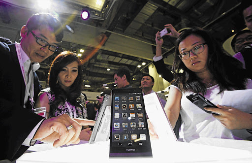 SMART THINKING: Visitors try out the Huawei Ascend P6 Android-based smartphone at its launch at the Communic-Asia information and communication technology exhibition in Singapore this week. The smartphone is the world's slimmest, weighs about 120g and features a 4.7-inch high-definition in-cell display