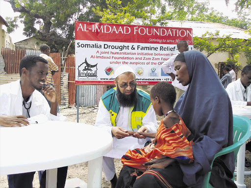 Yacoob Vahed, CEO and founder of the Al-Imdaad Foundation in South Africa, gives assistance to a child at the Waberi medical camp in Somalia Picture: AL-IMDAAD FOUNDATION