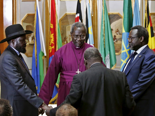 South Sudan's rebel leader Riek Machar (R) and South Sudan's President Salva Kiir (L) hold a priest's hands as they pray before signing a peace agreement in Addis Ababa in this May 9, 2014 file photo. Photo/REUTERS
