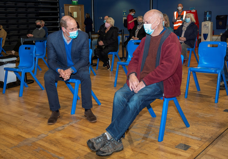 Britain's William, Duke of Cambridge speaks with Gooff Smyth, 66, who waits to be vaccinated, as he visits King's Lynn Corn Exchange Vaccination Centre, King's Lynn, Britain on Monday.