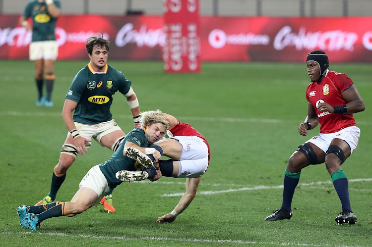 Faf de Klerk of the Springboks tackles Dan Bigger of the B&I Lions during the Castle Lager Lions Series 1st Test match between South Africa and British and Irish Lions at Cape Town Stadium on July 24, 2021 in Cape Town, South Africa.