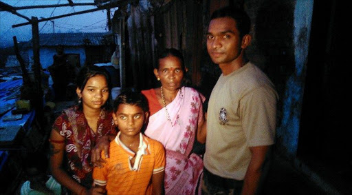 Indian police commando, Ganesh Raghunath Dhangade (R), poses for a photo with his family in Thane district on the outskirts of Mumbai. Dhangade who got lost as a child at a crowded railway station was reunited with his family after 24 years -- thanks to a tattoo on his arm. Dhangade was separated from his parents in 1989 aged just six when they were boarding a train. He ended up on his own in Mumbai, where he was cared for by a fisherman and then at two orphanages.