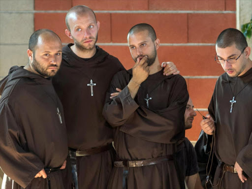 Friars gather after a funeral service for victims of the earthquake inside a gym in Ascoli Piceno, Italy August 27, 2016. /REUTERS