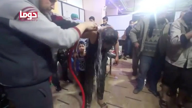 A man is washed following alleged chemical weapons attack, in what is said to be Douma, Syria in this still image from video obtained by Reuters on April 8, 2018.