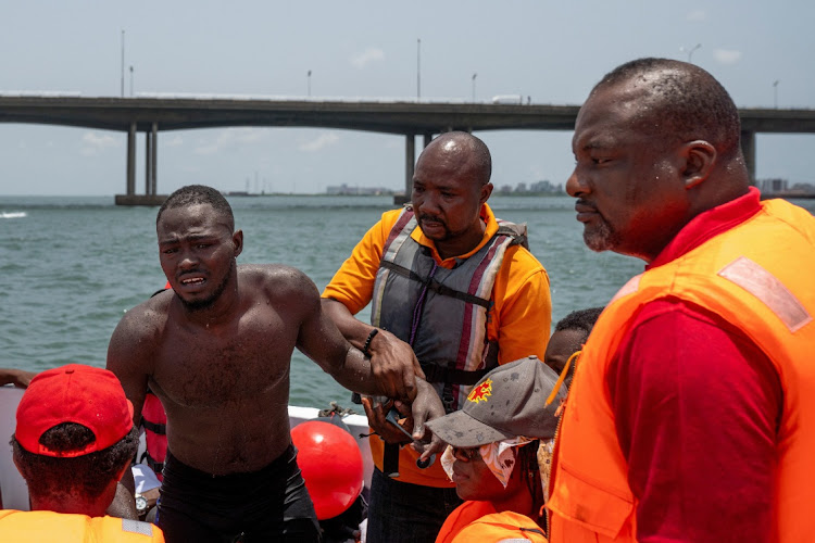 Akinrodoye Samuel team hands him over to a medical team after he completes his 11.8km 'Swim Against Suicide and Depression' in Lagos, Nigeria, on March 30 2024.