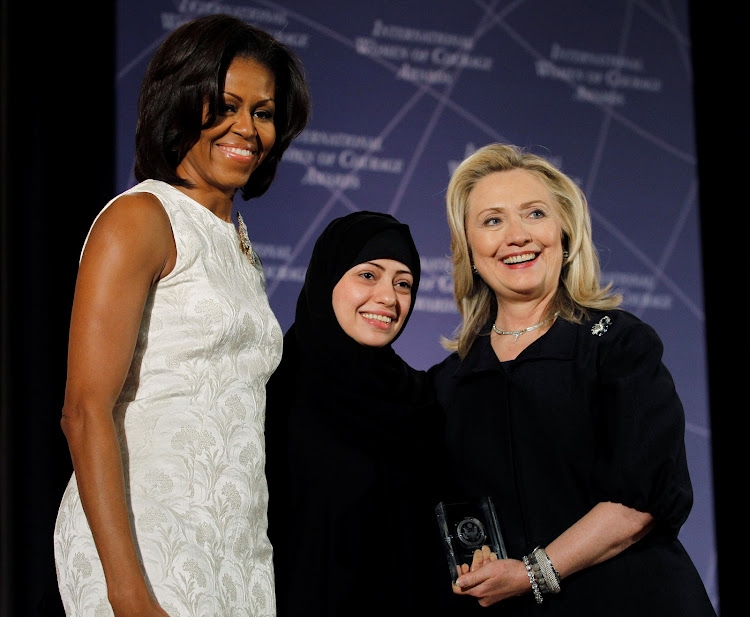 Michelle Obama (L) and Hillary Clinton congratulate Samar Badawi of Saudi Arabia during the State Department's 2012 International Women of Courage Award winners ceremony in Washington March 8, 2012.