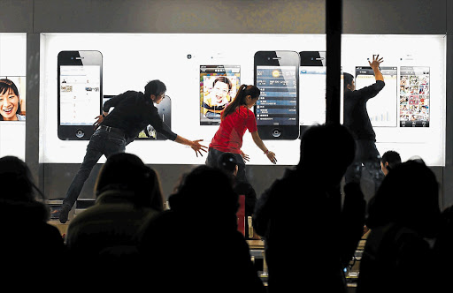 People wait outside an Apple store all night prior to the release of the new iPhone 4S.