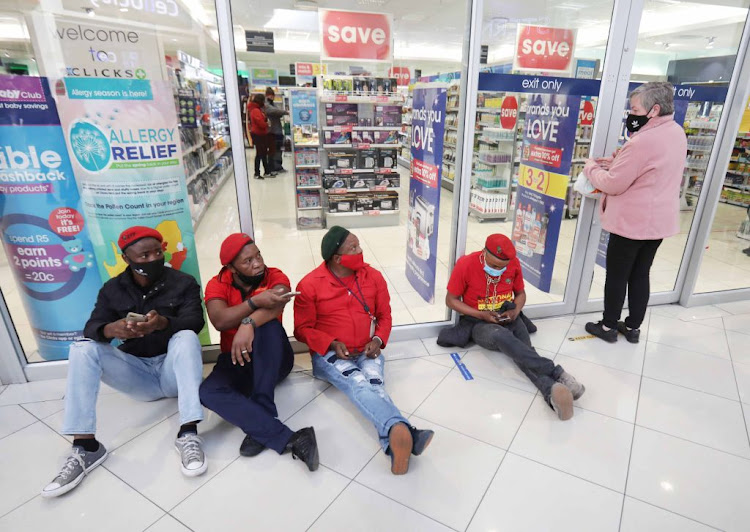 EFF members sit outside the entrance at Clicks at N1 City Mall, Cape Town, on September 10 2020. Clicks will resume normal operations after agreeing to a number of commitments with the EFF.