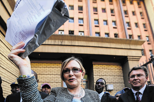 DA leader Helen Zille emerges from the Pretoria High Court brandishing a sealed bag containing a memory stick on which recordings of the so-called spy tapes are stored, after a five-year legal battle. File photo.