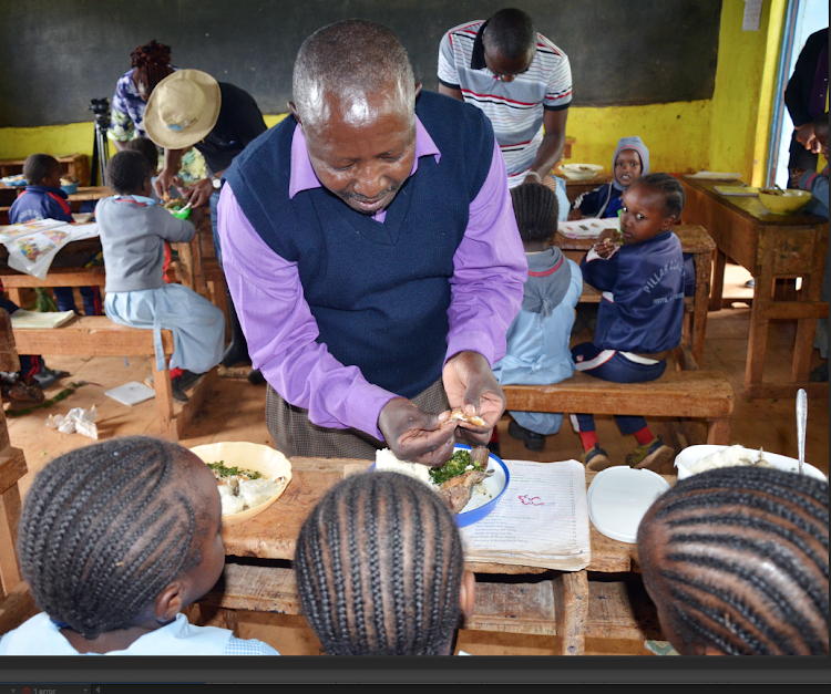 Gitunduti Primary and Junior Secondary School head James Mbatia leads other teachers in showing learners how to debone fish /KNA