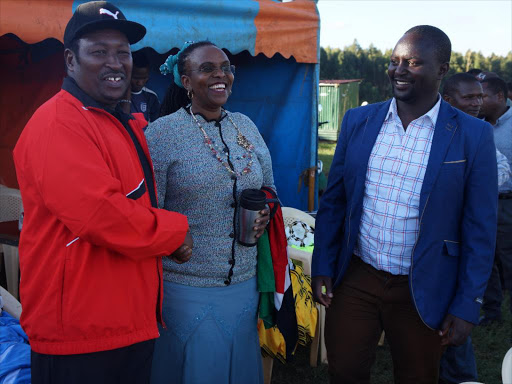 Former Limuru MP Peter Mwathi shakes hands with former TNA kiambu county cordinator Gladys Chania at Mabroukie stadium on Sunday while a participant welcome them.